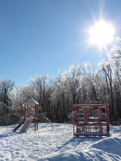 ice covered playground and bright, sunny, blue skies on a winter's day