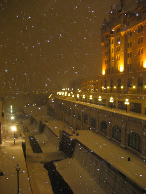 lights shining on the chateau laurier and snow falling on the ottawa rideau canal locks